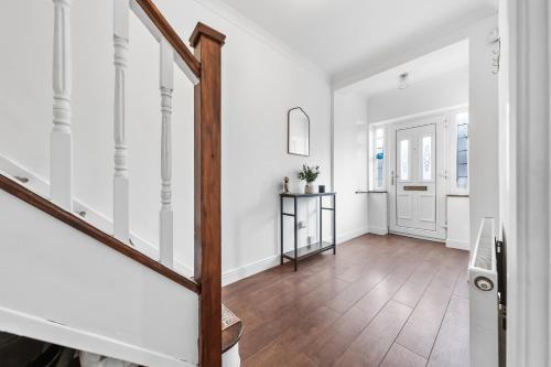 an empty hallway with white walls and a wooden staircase at The Aviator Heathrow in Harmondsworth