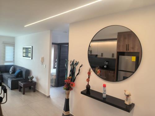 a living room with a mirror and a blue couch at Alojamiento Acogedor de la mejor zona de Loja in El Recreo