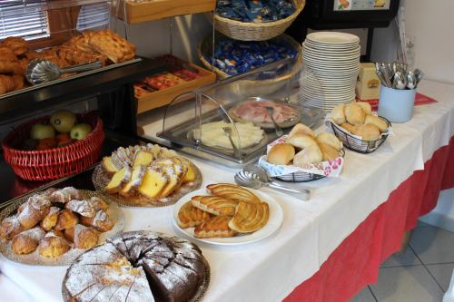 a table filled with different types of pastries and bread at Hotel Rezia in Sondalo