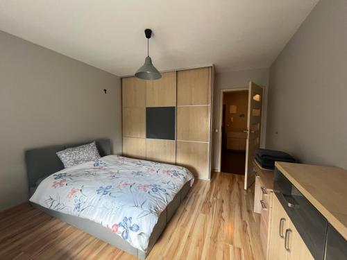a bedroom with a bed and a wooden floor at Apartament NA WRZOSACH in Kielce
