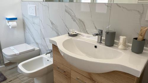 a white bathroom with a sink and a toilet at Elco Rooms Malpensa in Lonate Pozzolo