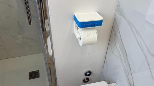 a bathroom with a toilet and a toilet paper holder at Elco Rooms Malpensa in Lonate Pozzolo