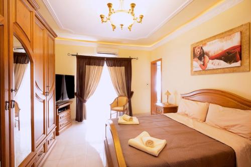 a bedroom with a large bed and a chandelier at Seafront living with private Garage in St. Paul's Bay