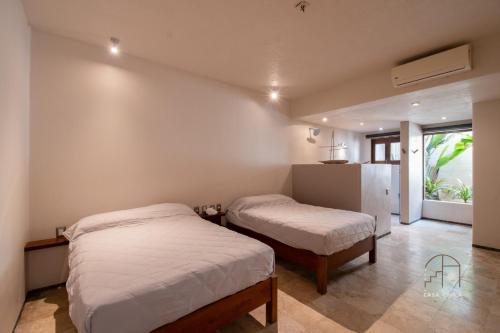 a bedroom with two beds and a refrigerator at Spectacular House with a Private Beach Front in Ixtapa-Zihuatanejo International