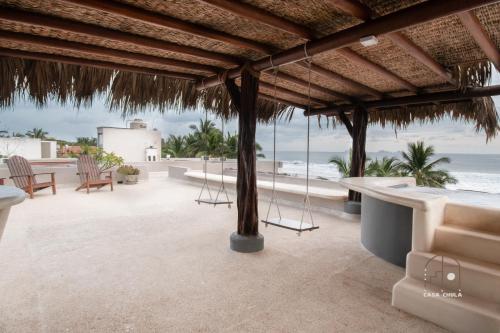 a patio with a view of the beach at Spectacular House with a Private Beach Front in Ixtapa-Zihuatanejo International