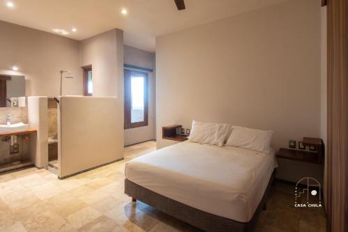 a bedroom with a large bed and a bathroom at Spectacular House with a Private Beach Front in Ixtapa-Zihuatanejo International