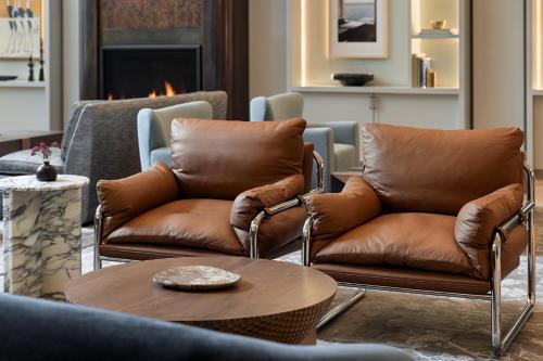 a living room with two leather chairs and a table at Kimpton Hotel Monaco Seattle by IHG in Seattle