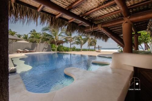 a swimming pool in a resort with a beach at Spectacular House with a Private Beach Front in Ixtapa-Zihuatanejo International