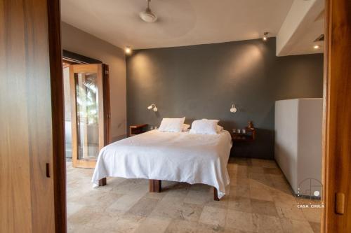 a bedroom with a large bed with white sheets at Spectacular House with a Private Beach Front in Ixtapa-Zihuatanejo International