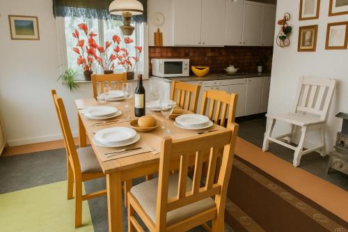 tavolo da pranzo con sedie e bottiglia di vino di Charming Swedish Summer Cottage - Happy Rentals a Motala