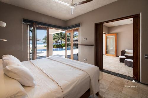 a bedroom with a large bed and a balcony at Spectacular House with a Private Beach Front in Ixtapa-Zihuatanejo International