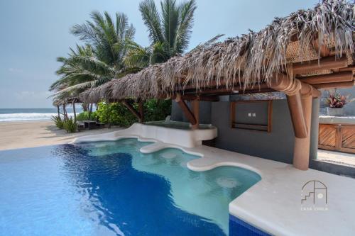 a resort with a swimming pool next to the beach at Spectacular House with a Private Beach Front in Ixtapa-Zihuatanejo International