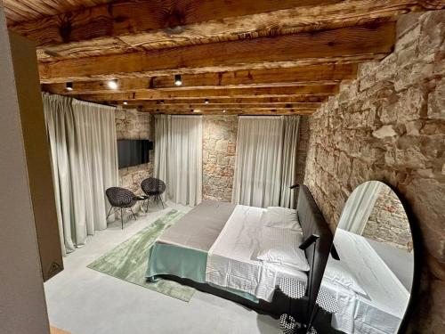 a bedroom with a bed and a stone wall at Piazza room in Split