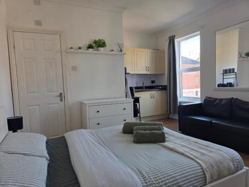 a bedroom with a bed and a couch and a kitchen at Studios & Ensuite Doubles - Central RG1 - Oracle - Station & Hospital in Reading