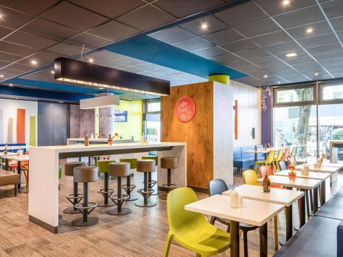 a restaurant with tables and chairs and a clock at ibis budget Berlin Kurfürstendamm - neu renoviert in Berlin