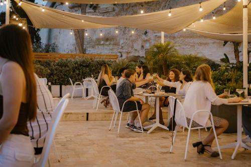 a group of people sitting at tables in a restaurant at Cugo Gran Macina Malta in Senglea