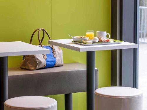 a table with a plate of food and a cup of coffee at ibis budget Berlin Kurfürstendamm - neu renoviert in Berlin