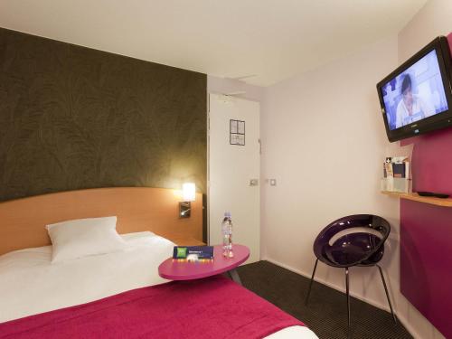 a hotel room with a bed and a tv at ibis Styles Bourg-en-Bresse Centre in Bourg-en-Bresse
