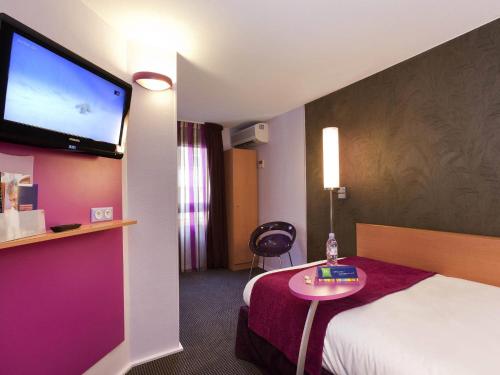 a hotel room with a bed and a flat screen tv at ibis Styles Bourg-en-Bresse Centre in Bourg-en-Bresse