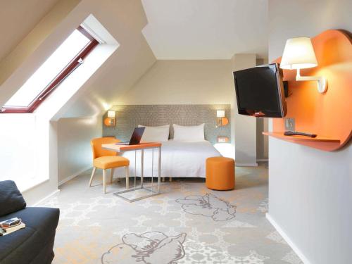 a bedroom with a bed and a tv in a room at ibis Styles Tours Centre in Tours