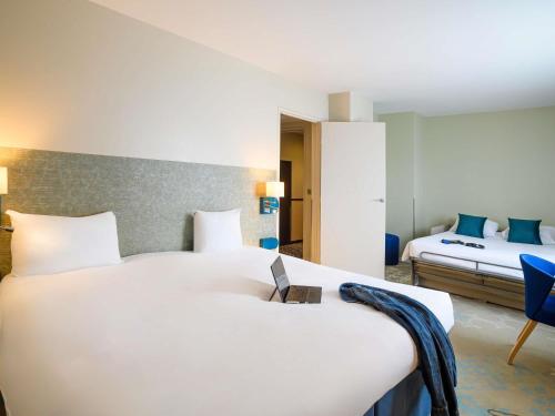 a hotel room with two beds and a laptop on the bed at ibis Styles Tours Centre in Tours