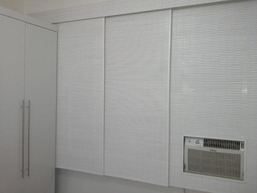 een groot raam met witte jaloezieën in een kamer bij Studio em Copacabana in Rio de Janeiro