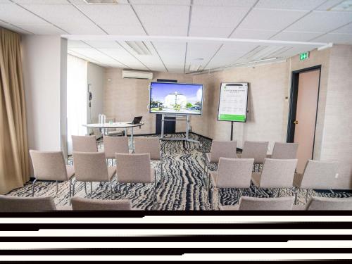 a conference room with chairs and a projection screen at ibis Styles Tours Centre in Tours