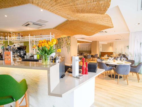 a kitchen and dining room with a counter with yellow flowers at ibis Styles Tours Centre in Tours
