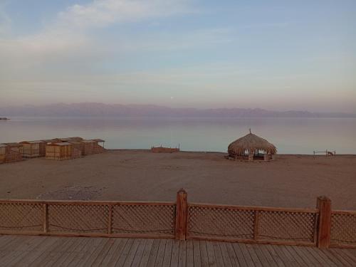a view of a beach with a hut and the water at Geo Tribe in Dahab