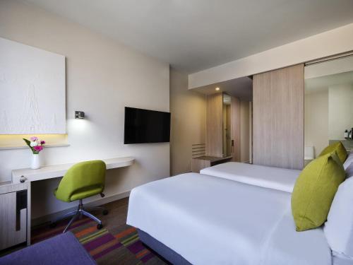 a hotel room with a large bed and a desk at Mercure Bangkok Siam in Bangkok