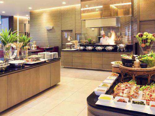 a buffet line with food on display in a restaurant at Mercure Bangkok Siam in Bangkok