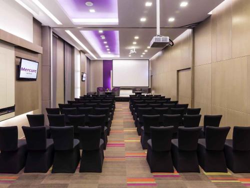 a conference room with black chairs and a projection screen at Mercure Bangkok Siam in Bangkok