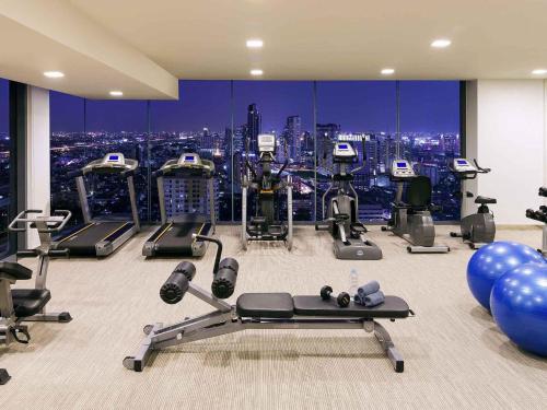 a gym with exercise equipment and a view of a city at Mercure Bangkok Siam in Bangkok