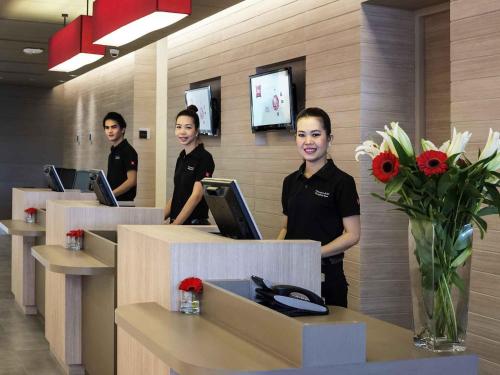 a group of men standing at a counter in an office at ibis Bangkok Siam in Bangkok
