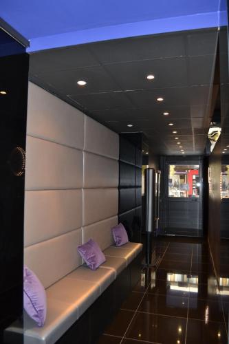 une chambre avec des oreillers violets assis sur un banc dans l'établissement Hotel Schtak, à Cannes