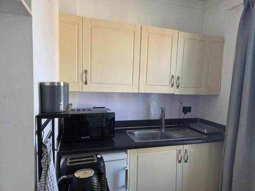 a small kitchen with a sink and a microwave at Studios & Ensuite Doubles - Central RG1 - Oracle - Station & Hospital in Reading