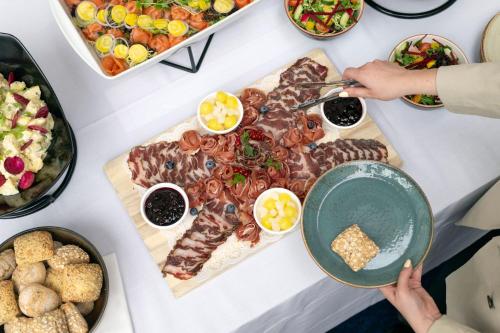 a table of food with meat and other foods at Ghent Marriott Hotel in Ghent