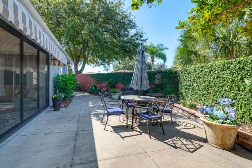 a patio with a table and chairs and an umbrella at Private Pool and Golf Cart! Villa By Spanish Springs in The Villages