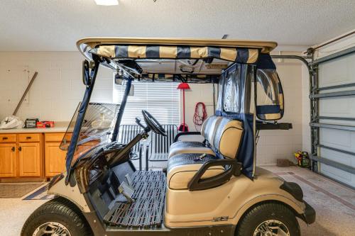 a golf cart in a garage with the door open at Private Pool and Golf Cart! Villa By Spanish Springs in The Villages