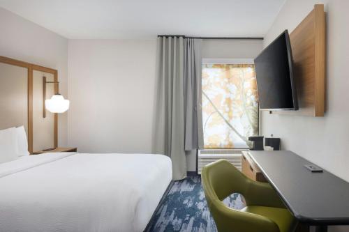 a hotel room with a bed and a desk and a window at Fairfield by Marriott Mission Viejo Orange County in Mission Viejo