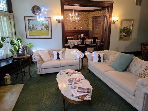 a living room with two couches and a table at The Kings Throne Inn and Guest House in Toledo
