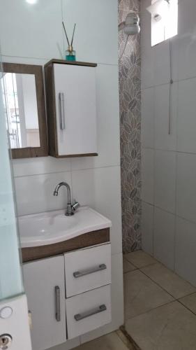 a bathroom with a sink and a mirror and a shower at Kitnet - Itabuna-Ba in Itabuna
