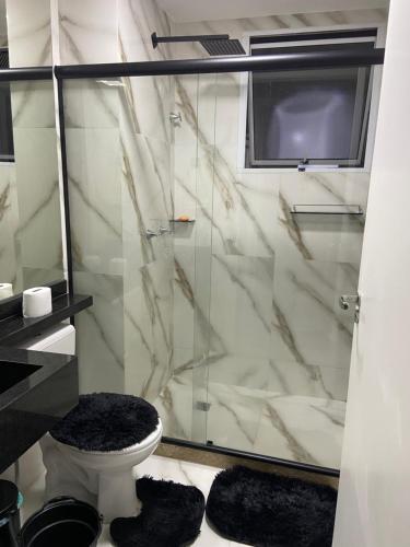 Un baño con inodoro y ducha de cristal. en Apt Santa Cruz, en Santa Cruz