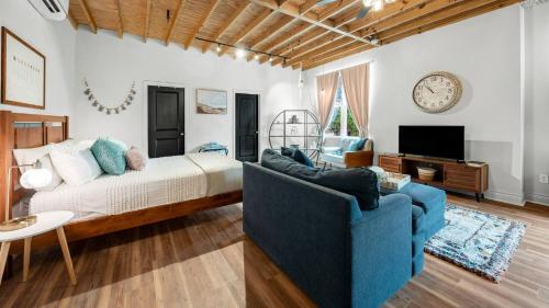 a bedroom with a bed and a blue couch at Charming & Spacious Hideaway by Downtown Bryan in Bryan