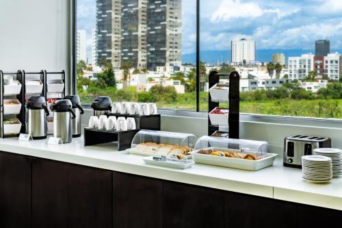 a buffet line with food and a view of a city at Holiday Inn Express & Suites Puebla Angelopolis by IHG in Puebla