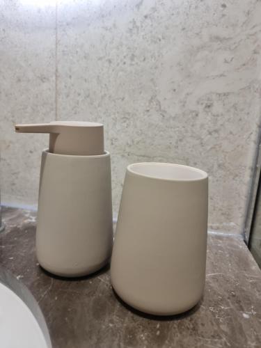 two white vases sitting on a counter in a bathroom at KC Apartments 3 in Berat