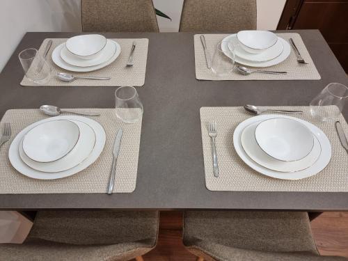 a table with white plates and silverware on it at KC Apartments 3 in Berat