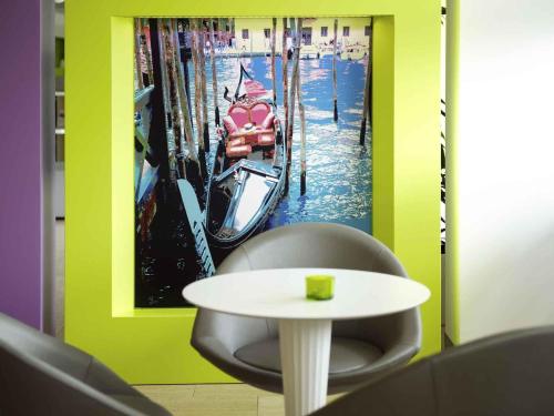 a room with a table and a picture of a boat at Hotel Mercure Venezia-Marghera in Marghera
