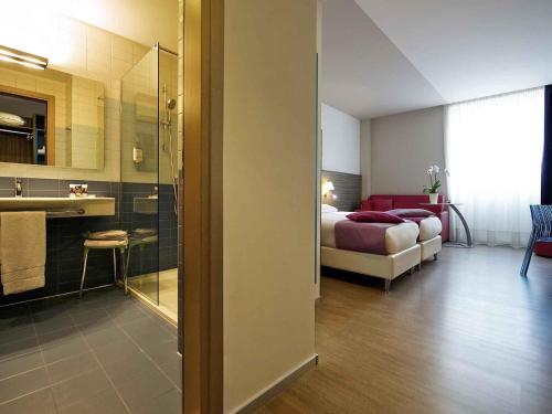 a hotel room with a bed and a bathroom at Hotel Mercure Venezia-Marghera in Marghera