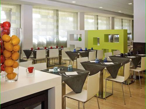 a dining room with tables and chairs with oranges on them at Hotel Mercure Venezia-Marghera in Marghera